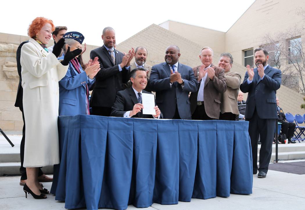 Victor Joecks/ Special to the Pahrump Valley Times
Legislators applaud as Gov. Brian Sandoval holds up SVB58 after signing it during a ceremony kicking off 2017 Veterans and Military Day at the Le ...