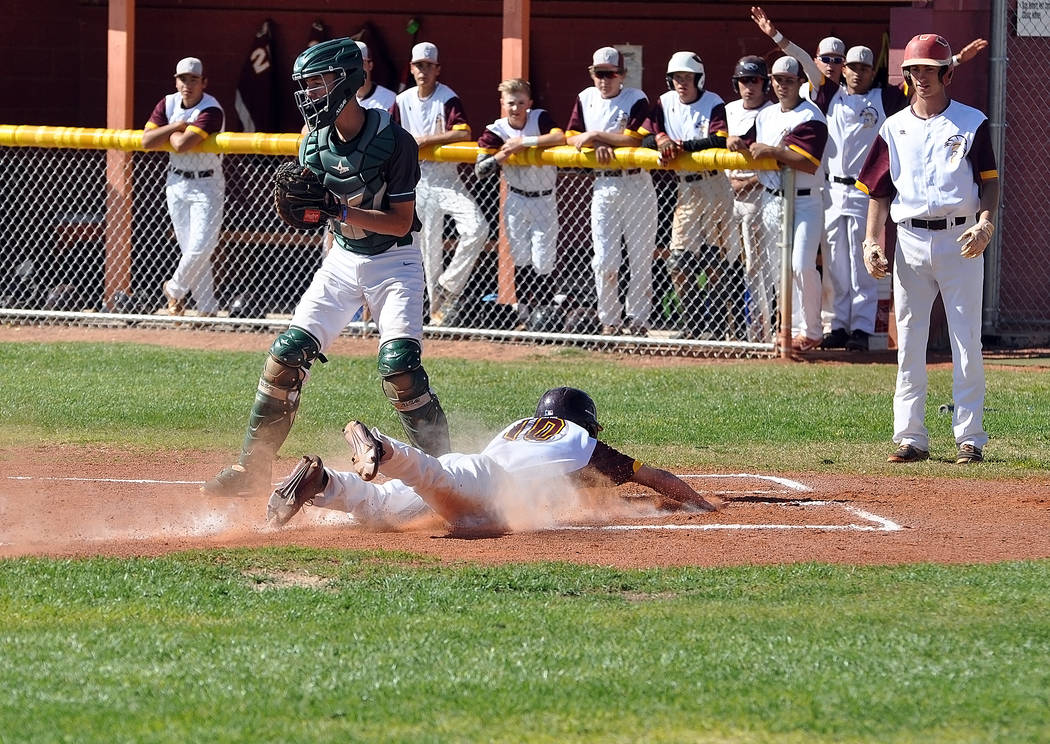 Horace Langford Jr. / Pahrump Valley Times -
Drew Walker dives into home plate for the Trojans on Tuesday against Virgin Valley. The Trojans are 4-7 in non-league play, with league play starting o ...