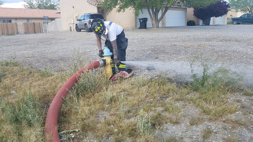 David Jacobs/Pahrump Valley Times
A Pahrump Valley firefighter works on a fire hydrant along Bourbon Street. A fire burned an apartment there on March 31. No one was hurt in the fire.