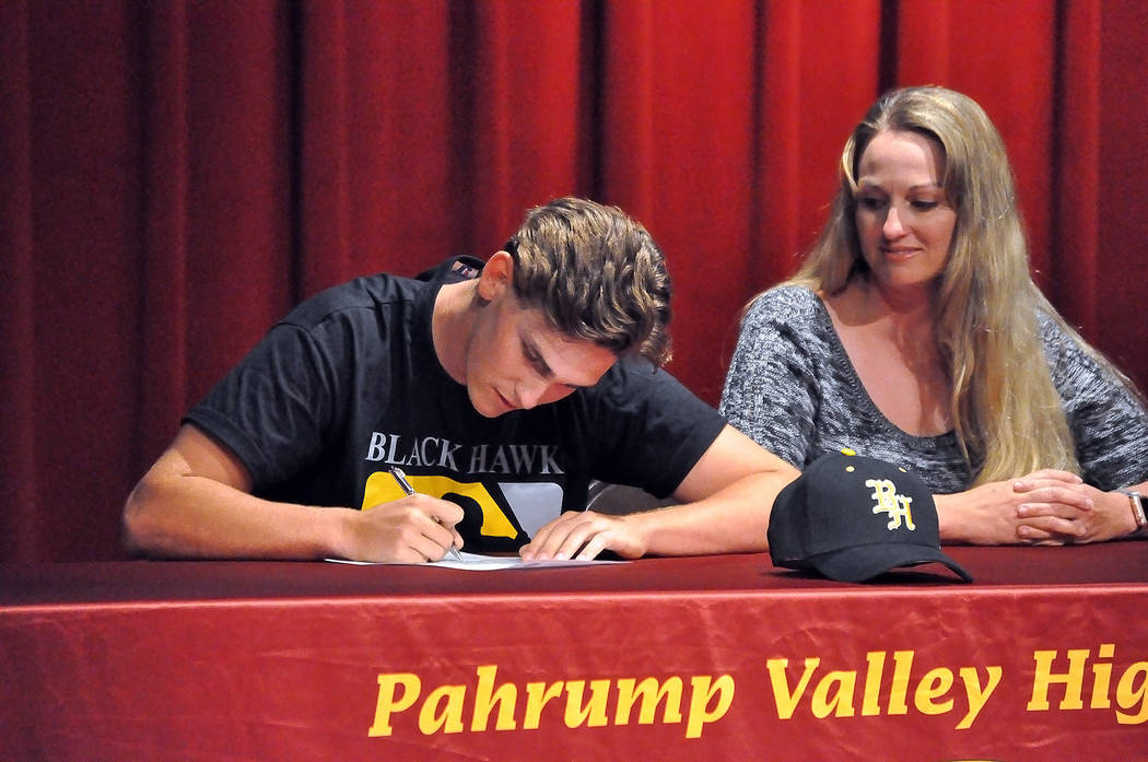 Horace Langford Jr. / Pahrump Valley Times - Parker Hart signs his college letter of intent for Black Hawk College, a small college in Moline, Illinois, while his mother, Laura Daun looks on.  Har ...