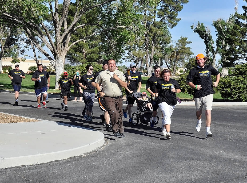 Horace Langford Jr./Pahrump Valley Times
Sergeant David Boruchowitz, Nye County Sheriff’s Office spokesman, runs with Ashlin Johnson and Brady Freeman at the Law Enforcement Torch Run on May 5 t ...