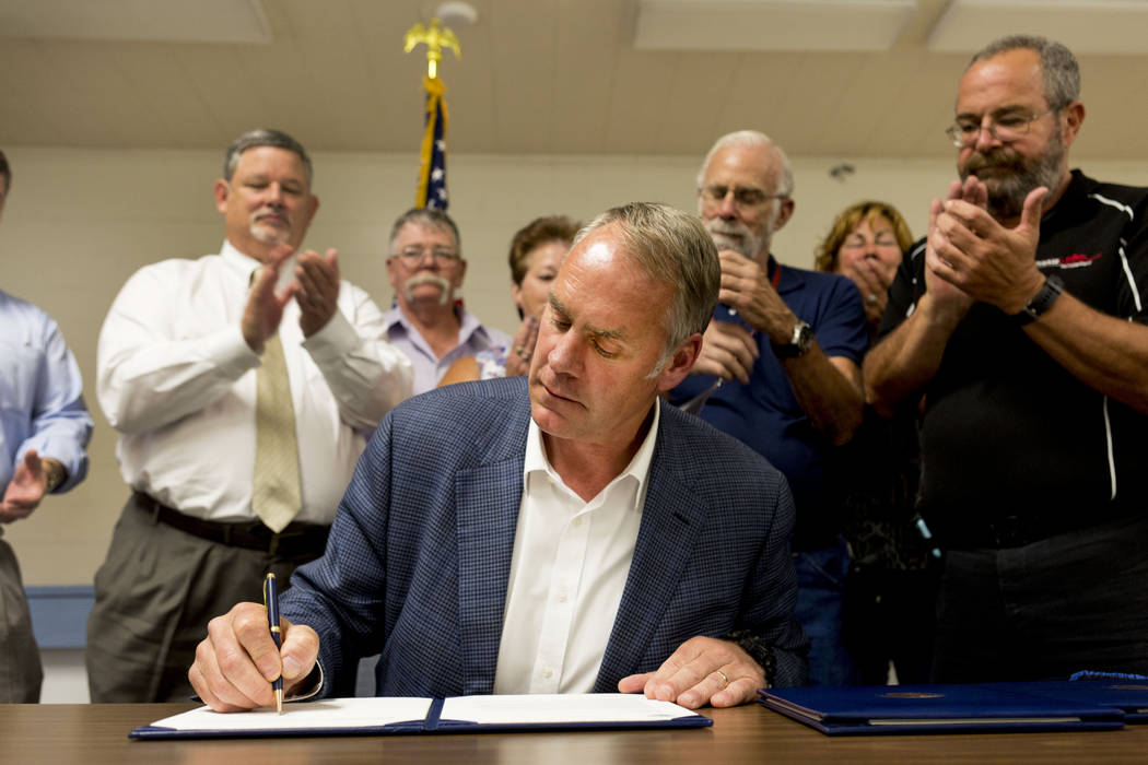 U.S. Secretary of the Interior Ryan Zinke signs a letter authorizing the distribution of federal money to Lincoln County at the Bob Ruud Community Center in Pahrump, Monday, June 26, 2017. Elizabe ...