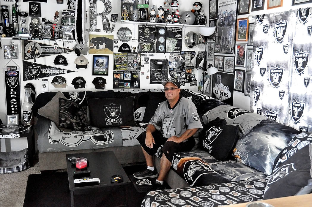 Horace Langford Jr./Pahrump Valley Times -   The sheer mangnitude of all the Raider's memorabilia in the house can be seen when home owner "Raider Rob" sits on his couch.