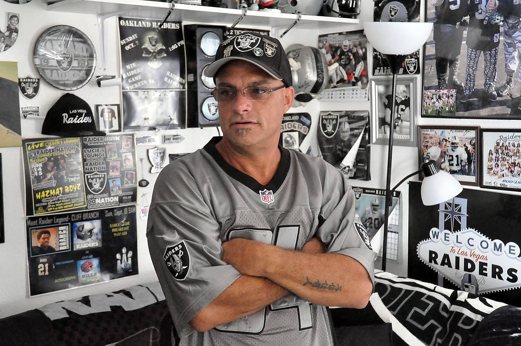 Horace Langford Jr./Pahrump Valley Times -  "Raider Rob" stands in his living room. Every inch of wall space is covered with Raider gear. It took him three months to hang up all the Raider memorab ...