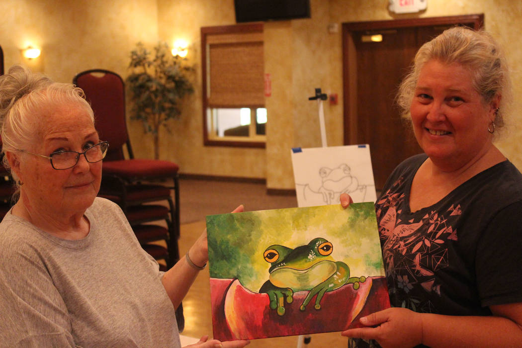 Jeffrey Meehan/Pahrump Valley Times
Doris Smith, student (left), and Laurie McCaslin instructor (right), hold a Prince Charming painting on Aug. 12, 2017. McCaslin instructs a three-hour course ev ...