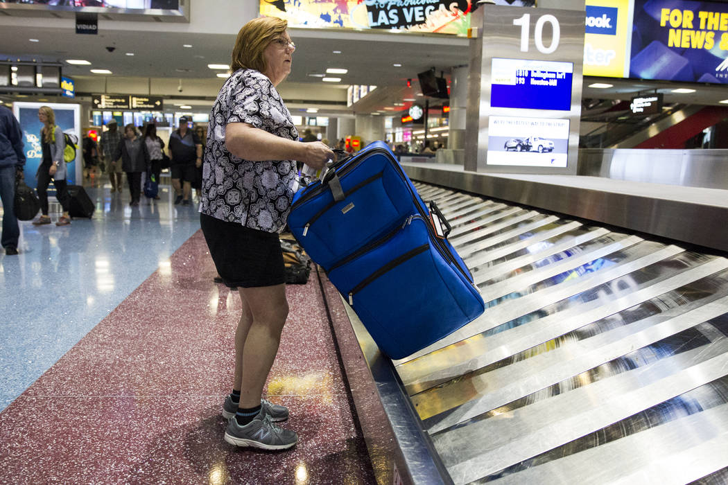 Allegiant Air passenger Michele Connelly of Richmond, Va.,  picks up her luggage at McCarran International Airport in Las Vegas on Wednesday, Aug. 9, 2017. Erik Verduzco Las Vegas Review-Journal @ ...