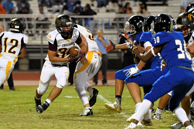 Peter Davis / Special to the Pahrump Valley Times 

Nico Velazquez carries the ball for the Trojans towards a sea of blue. The play shows the deep penetration of the Jaguar defensive line, which w ...