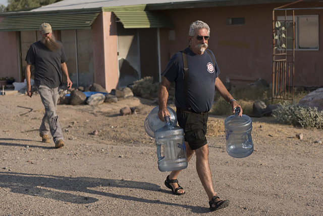 Larry Levy, fire chief with Southern Inyo Fire Protection District, right, and Jim Furlough, make their weekly potable water delivery rounds to residents in Tecopa, California on June 21. Jason Og ...