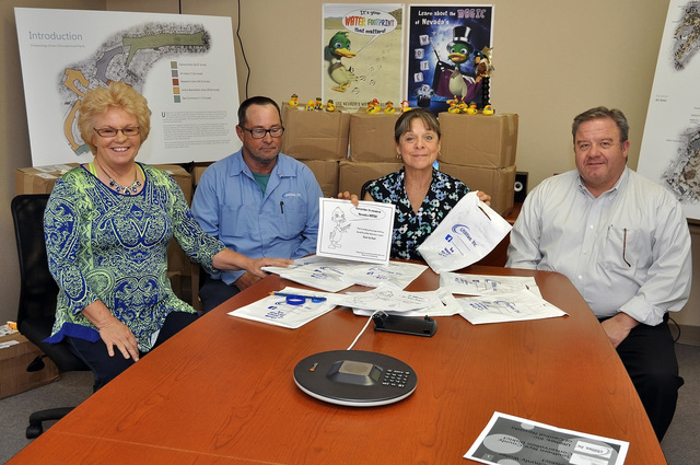 Utilities Inc. water conservation coordinator Debby Woodland (far left), Utilities, Inc. area manager Bill Coates (second form left) and Donna Lamm from the Nye County Conservation District delive ...