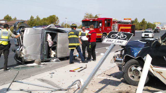 Pahrump Valley Fire and Rescue crews assess the condition of a driver who plowed into three parked vehicles at the Carlotta Business Plaza late Monday morning. The driver was transported to Desert ...