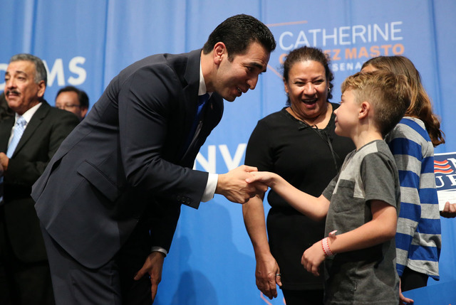 Congressman-elect Ruben Kihuen, left, shakes the hand of a young supporter during the Nevada State Democratic Party at the Aria in Las Vegas on General Election night Tuesday. The former state sen ...