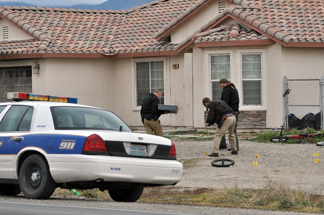Nye County Sheriff's Office investigators place numbered markers on spent shell casings found outside a home on S. Blagg Road. after an unknown man fired shots at a vehicle driving by the area.

H ...