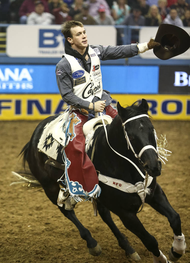 Tim O'Connell of Zwingle, Iowa takes a victory lap on Mucho Dinero after riding in the bareback competition in the tenth go-round of the National Finals Rodeo, Saturday, Dec. 16, 2017, at the Thom ...