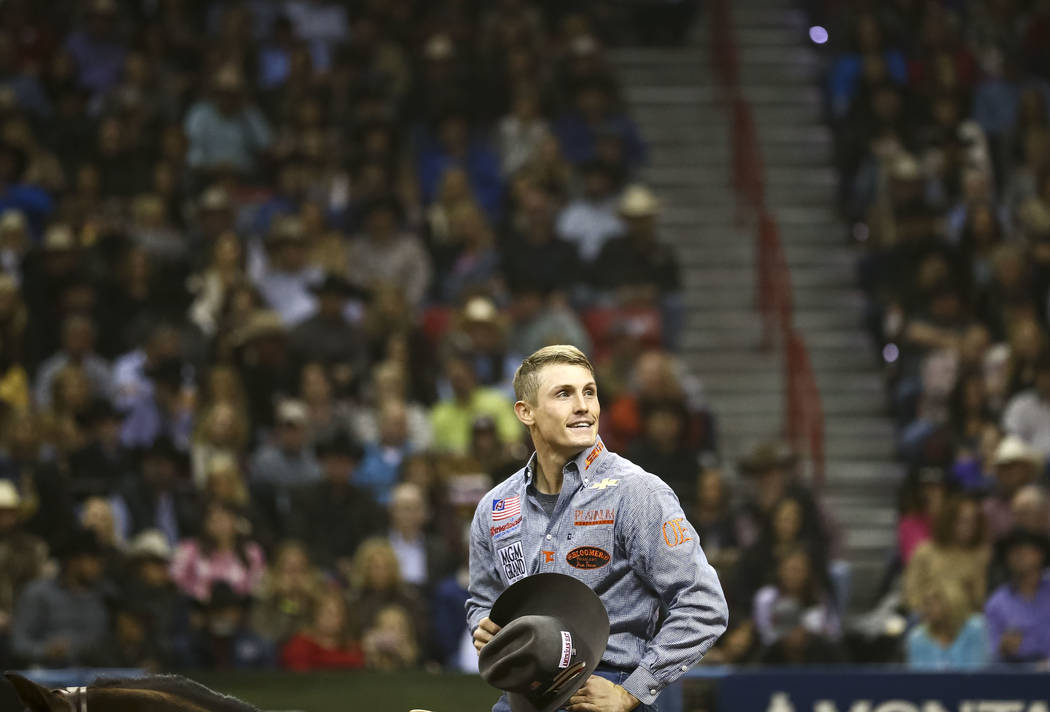 Tuf Cooper of Weatherford, Texas looks on after taking part in the tie-down roping competition in the tenth go-round of the National Finals Rodeo, Saturday, Dec. 16, 2017, at the Thomas & Mack ...