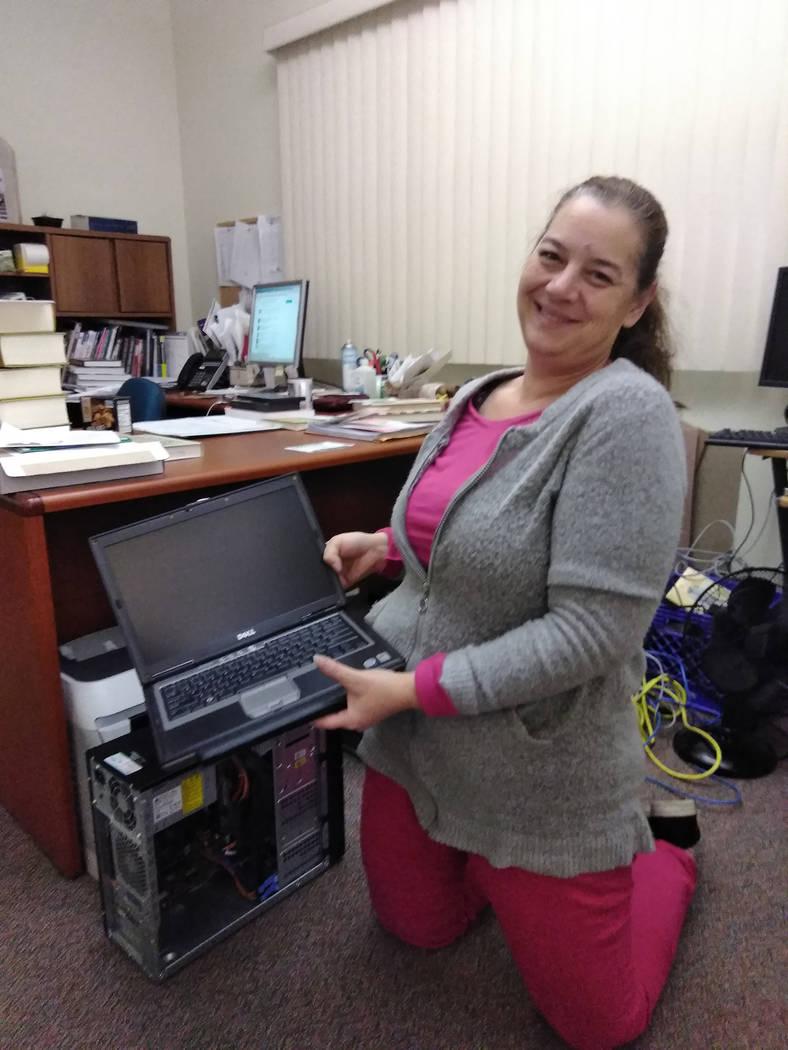 Selwyn Harris/Pahrump Valley Times 
Pahrump Community Library Reference Clerk Amy Bruno holds an old laptop computer destined to be recycled on Saturday Jan. 6. Officials from Nevada State Recycle ...
