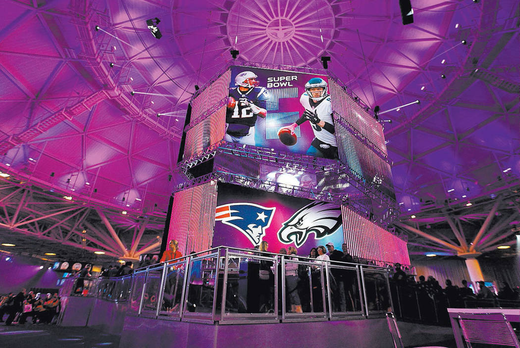 A banner featuring New England Patriots quarterback Tom Brady, left, and Philadelphia Eagles quarterback at the NFL Experience at the Minneapolis Convention Center in Minneapolis, Minn., Friday, F ...