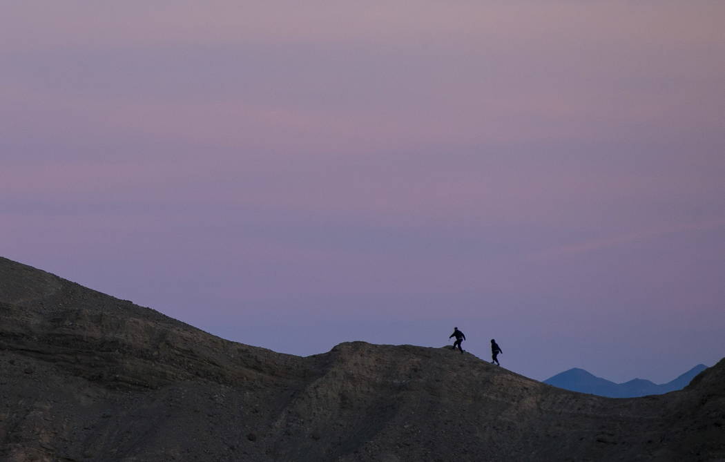 Chase Stevens/Las Vegas Review-Journal 
People, seen looking east from Zabriskie Point, make their way up a ridge before sunset in Death Valley National Park, California, on Wednesday, Jan. 24, 2018.
