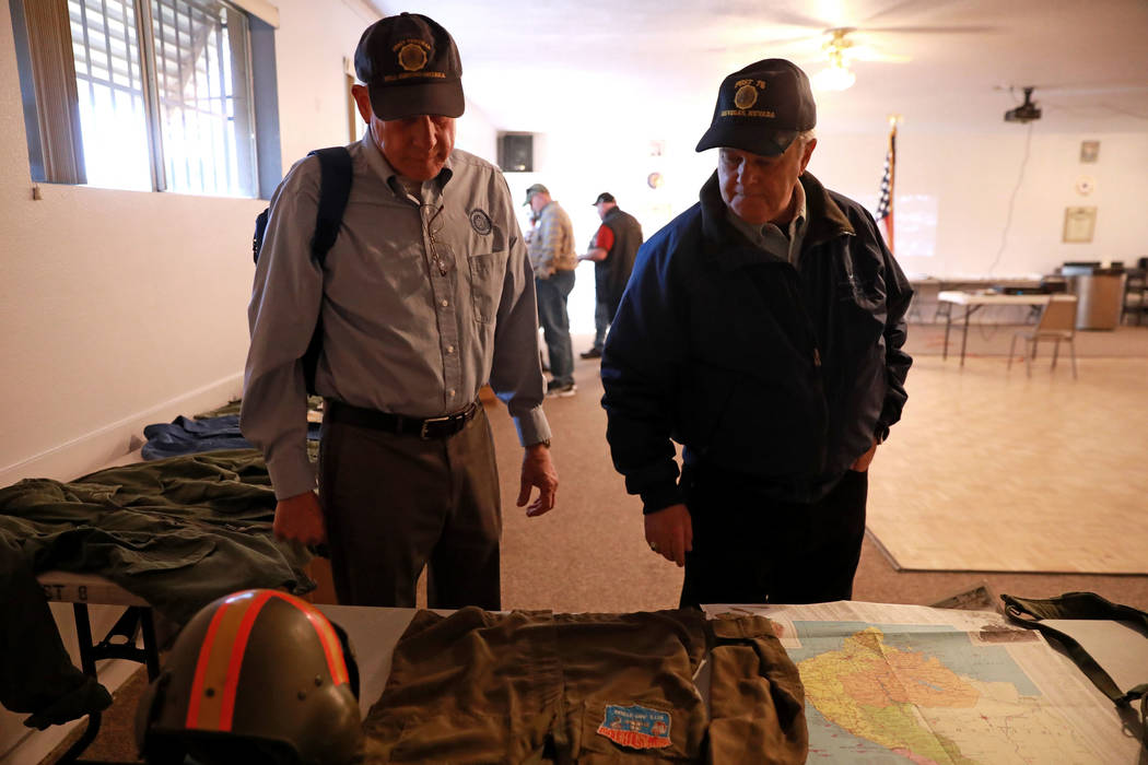 Veterans Stephen Daugherty, left, and Joel Forman look at different war memorabilia during a 50th anniversary event remembering the Vietnam War Tet Offensive at the American Legion Vegas Post 8 in ...