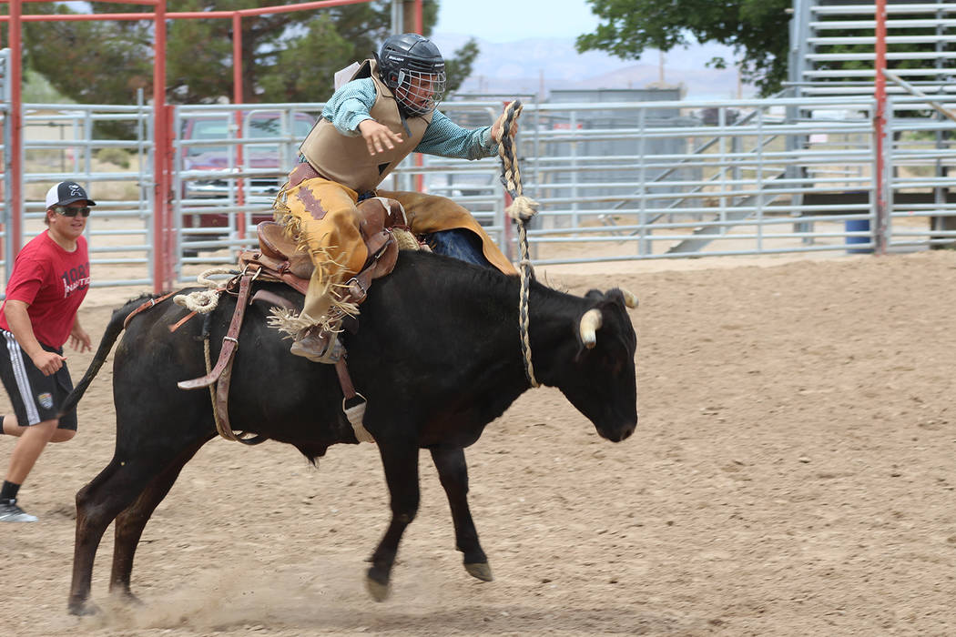 Tom Rysinski/Pahrump Valley Times Austin Friener rides under the watchful eye of Kody Peugh at a Pahrump Valley High School rodeo club practice Sunday morning at McCullough Arena in Pahrump.