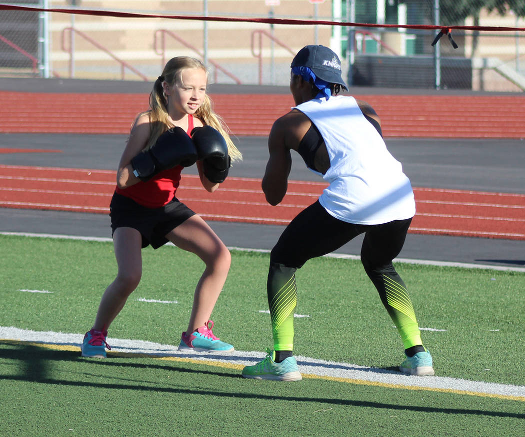 Tom Rysinski/Pahrump Valley Times Dominique Maloy puts McKenna Cunningham, 10, through a drill during Sunday morning's session of Maloy's "A Youth Sports Experience" at Pahrump Valley High School' ...