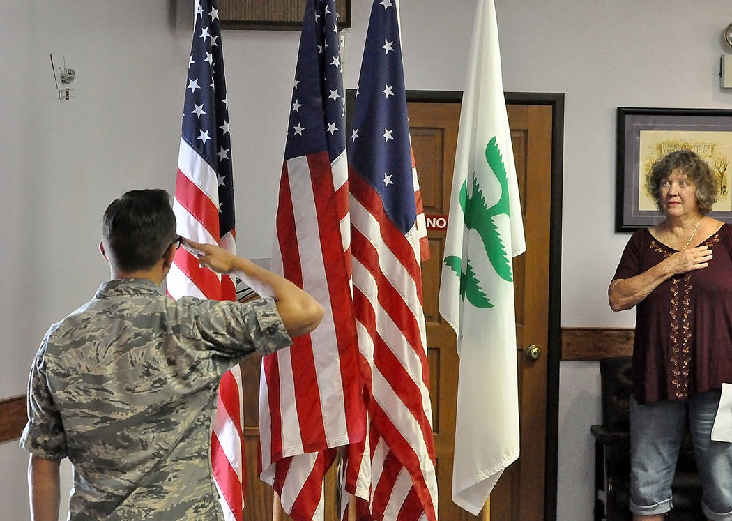 Horace Langford Jr./Pahrump Valley Times A member of Pahrump's Civil Air Patrol salutes the flag as a Pahrump Elks Lodge member shows reverence by holding her hand over her heart during Friday's F ...