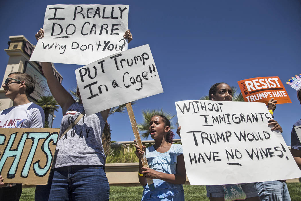 Paige Faggins, middle, protests outside Suncoast hotel-casino ahead of President Donald Trump's appearance on Saturday, June 23, 2018, in Las Vegas. "I'm here because Trump is separating fami ...