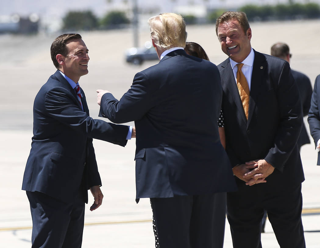 President Donald Trump greets Attorney General Adam Laxalt, Republican candidate for Nevada governor, left, and U.S. Sen. Dean Heller, R-Nev., at McCarran International Airport in Las Vegas on Sat ...