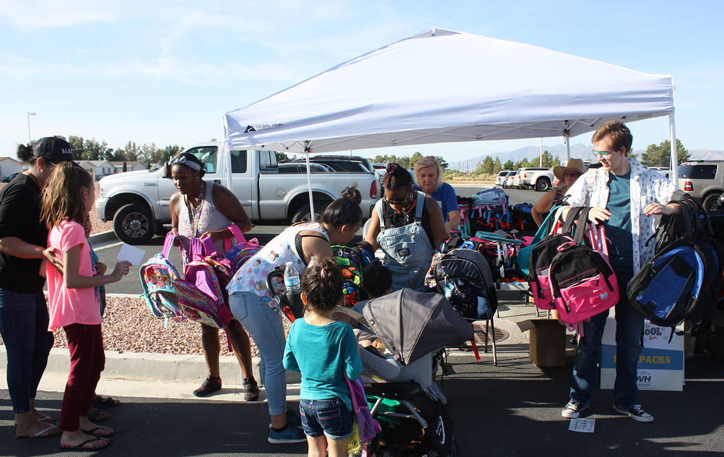 Robin Hebrock/Pahrump Valley Times Back to School Health Fair volunteers are pictured with armfuls of backpacks, assisting the children in selecting just the right one for them.
