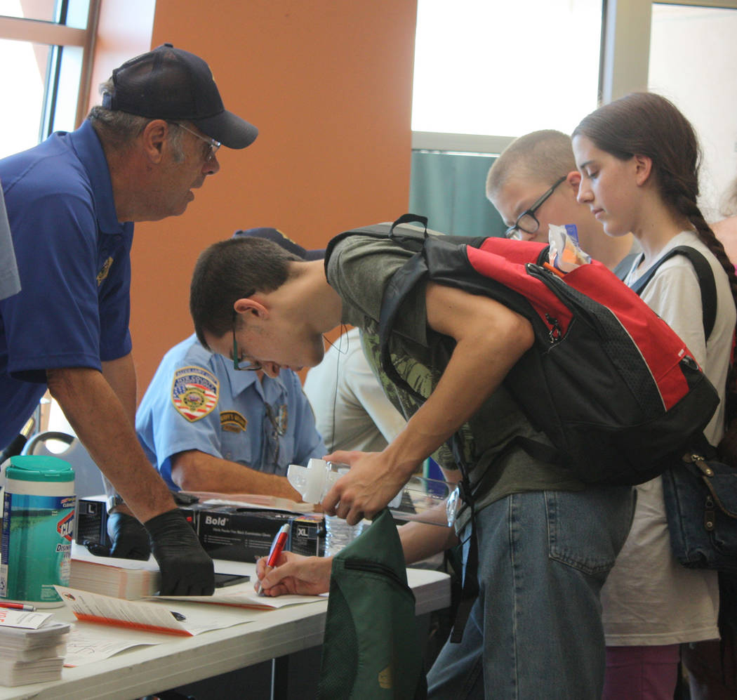 Robin Hebrock/Pahrump Valley Times The Nye County Sheriff's Office helped out at the health fair with identity kits for valley kids. A young man is shown filling out his information on one of thes ...