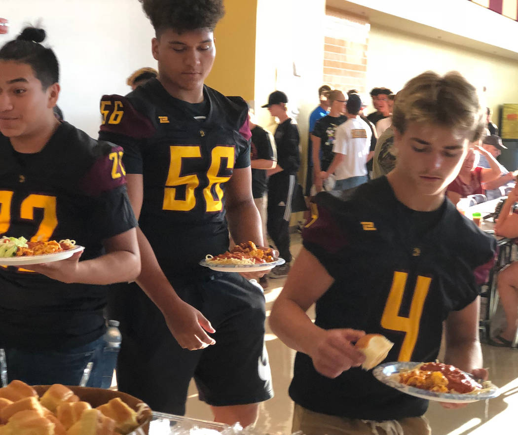 Tom Rysinski/Pahrump Valley Times Anthony Peralta (22), Brandon Bunker (56) and Donnie MIller (4) load up their plates with pasta, salad and dinner rolls at the Pahrump Valley High School football ...