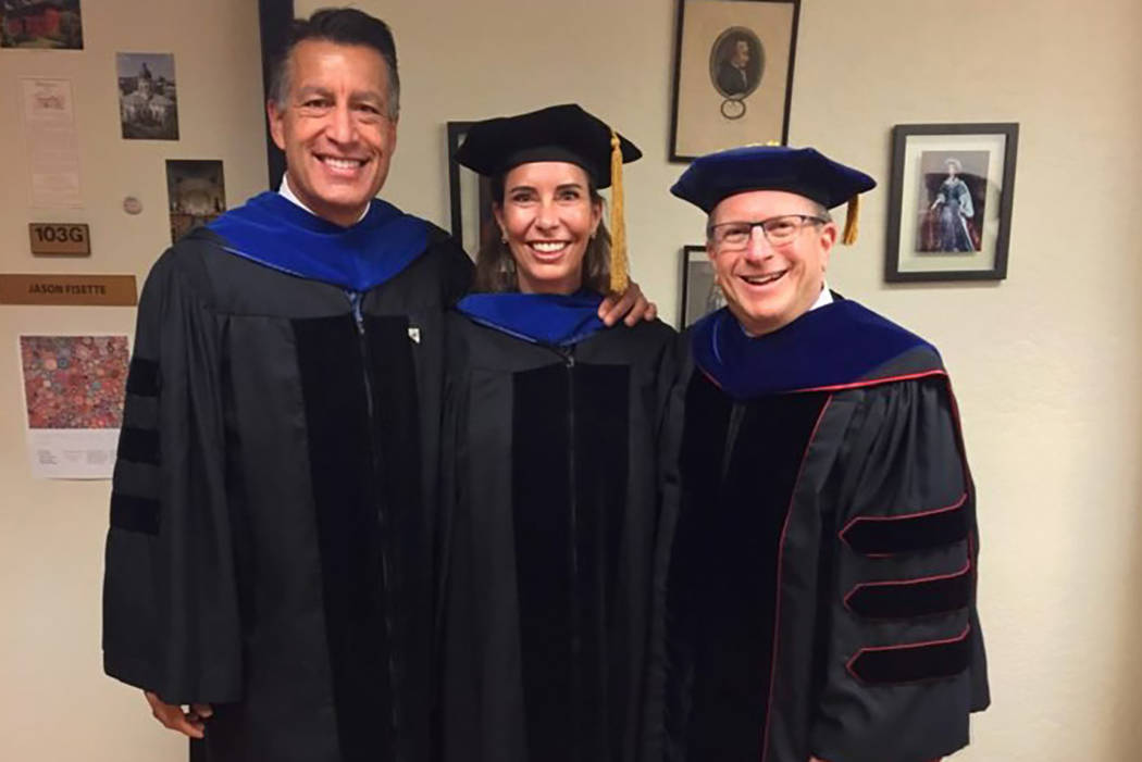 From left to right, Governor Brian Sandoval, Lauralyn McCarthy and Dean Al Stavitsky pose before the 2018 Spring Reynolds School Commencement. (UNR)