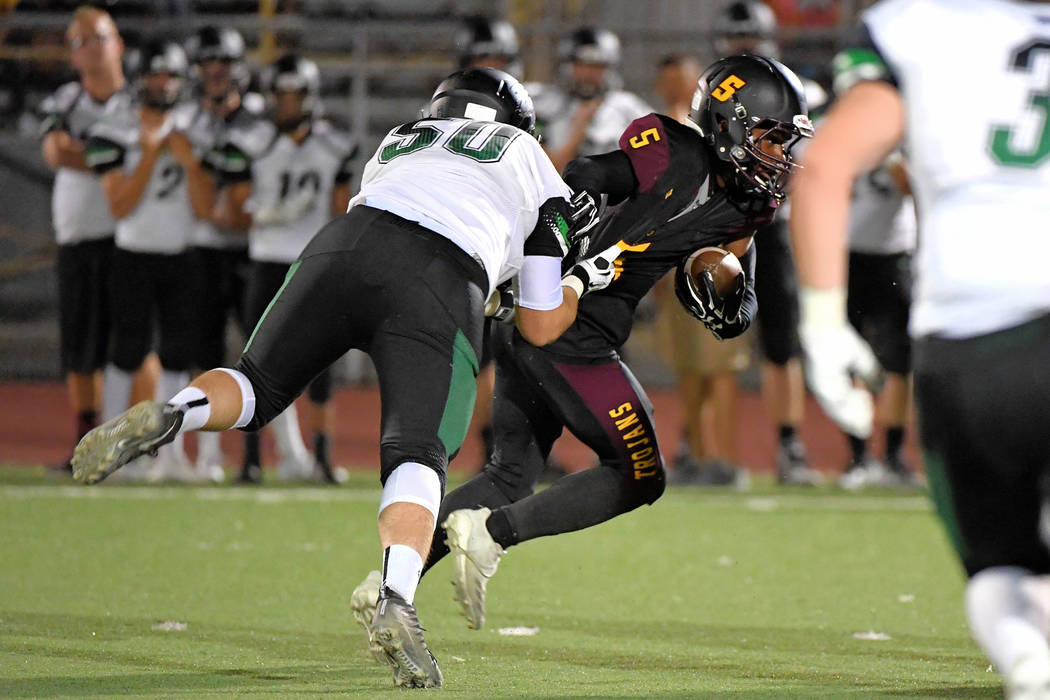 Peter Davis/Special to the Pahrump Valley Times Casey Flennory of Pahrump Valley tries to elude Virgin Valley defensive end Riley Waite during the Bulldogs' 26-24 win over the Trojans last Friday ...