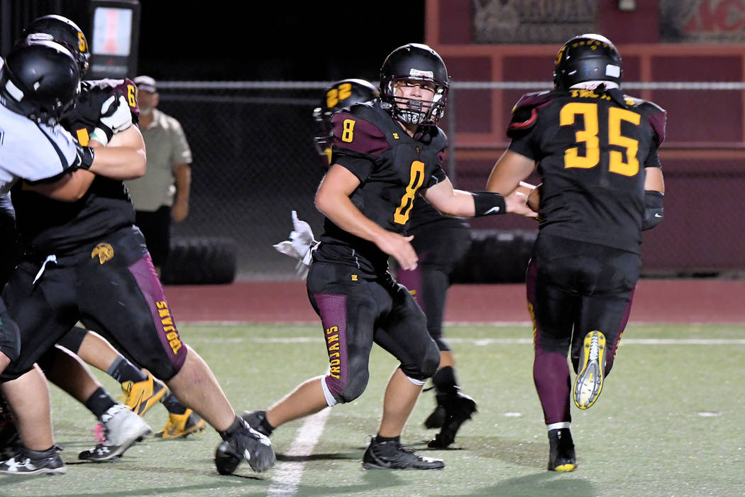 Peter Davis/Special to the Pahrump Valley Times Pahrump Valley quarterback Tyler Floyd keeps an eye on the line while handing off to Nico Velazquez during last week's game against Virgin Valley in ...