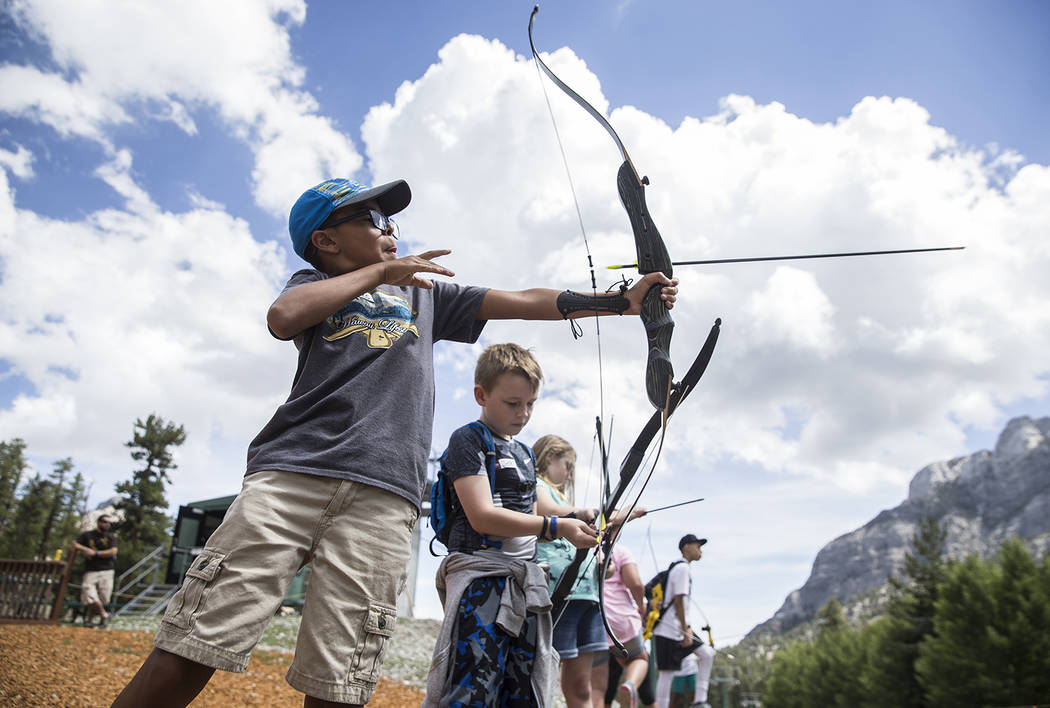 Benjamin Hager/Las Vegas Review-Journal James Mendoza, left, practices his archery skills during Youth Adventure Day on July 20 at Lee Canyon.