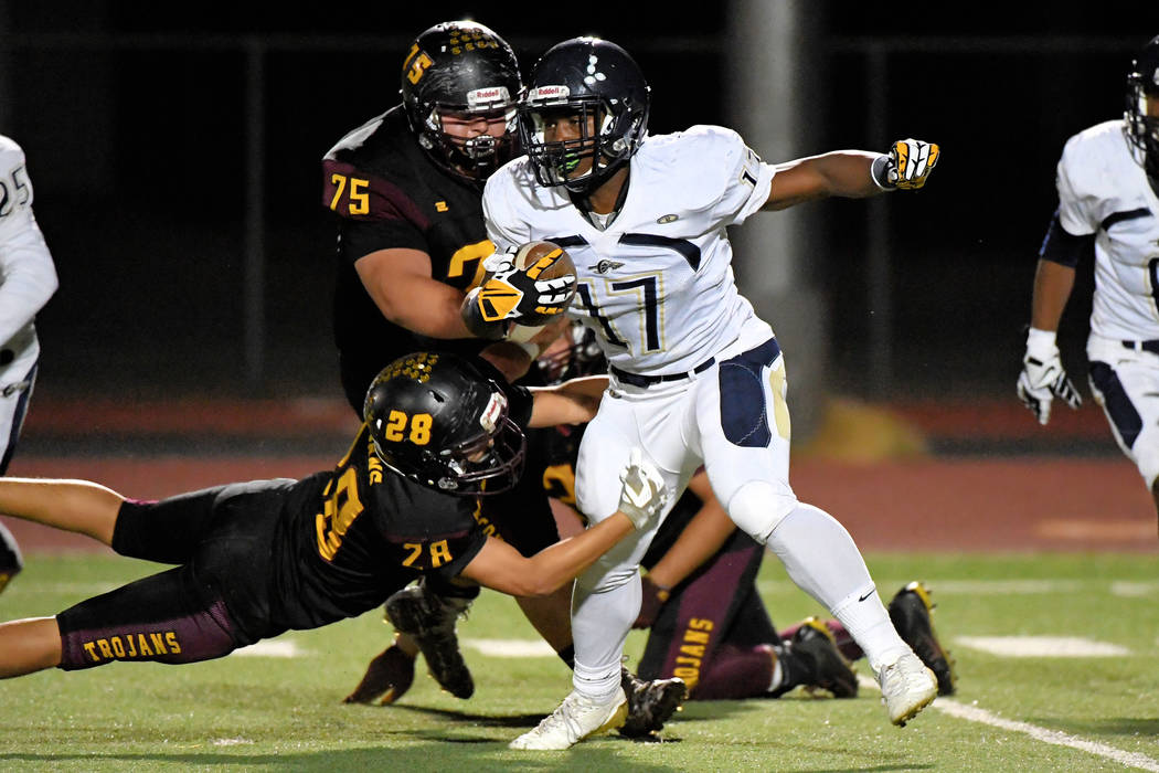 Peter Davis/Special to the Pahrump Valley Times Pahrump Valley seniors Zach Trieb (75) and Dylan Grossell (28) combine to stop Cheyenne's sophomore running back Majae Madison during Friday night's ...
