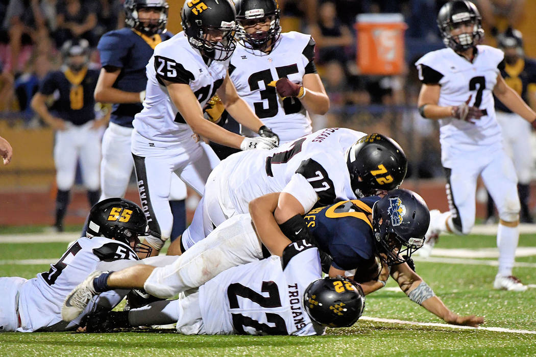Peter Davis/Special to the Pahrump Valley Times Kody Peugh (55), Caleb Sproul (72) and Anthony Peralta (22) team up to make a tackle during a Sept. 7 game against Boulder City.