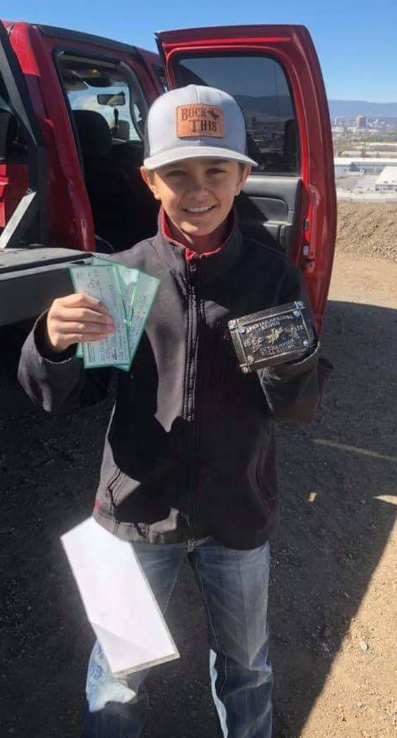Buddy Krebs/Special to the Pahrump Valley Times Brandon Mountz of Pahrump shows off the checks and a buckle he won for his performances in bull riding and bareback steer riding at a junior high sc ...