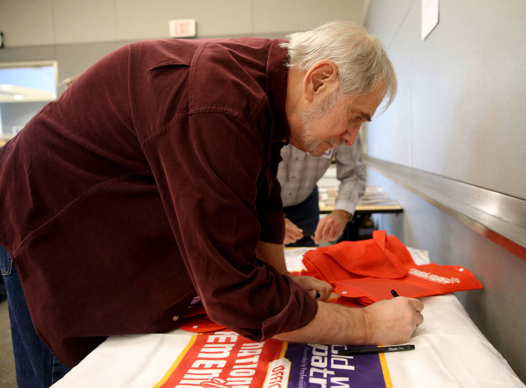 Cold War Patriot Art Goldberger of Las Vegas signs a banner during the Official National Day of Remembrance honoring all Nevada Test Site workers, their family members and friends at National Atom ...