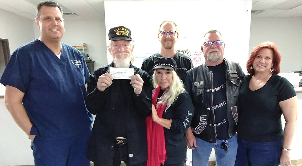 Selwyn Harris/Pahrump Valley Times Tribe Motorcycle Club President Ralph "Red" Pillman, holding a $500 check, is joined by his wife Joanna, along with Dr. Michael Taylor, left. Rounding out the gr ...