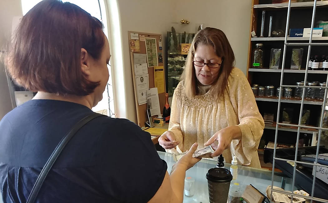 Selwyn Harris/Pahrump Valley Times All About Hemp's Andrea Nixon completes a transaction on Saturday morning during the business' grand opening event. Co-owner Jim McCoy said he was quite pleased ...