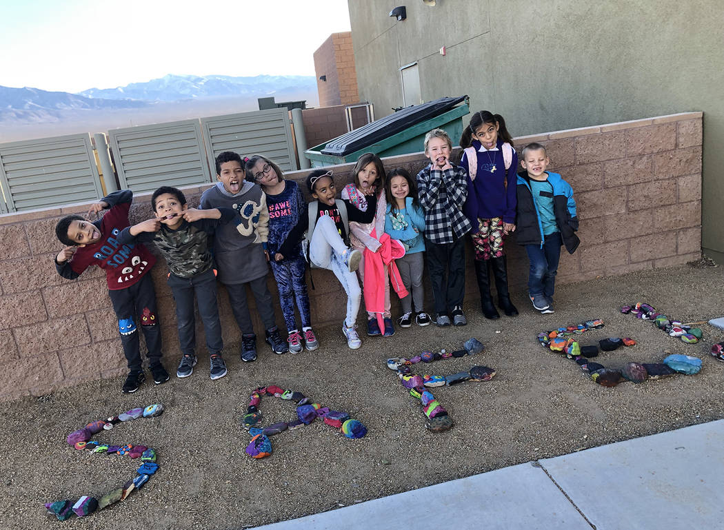 Special to the Pahrump Valley Times Local elementary school students enrolled in the school district's SAFE program, strike poses before colorful rocks painted during a recent parent engagement ni ...
