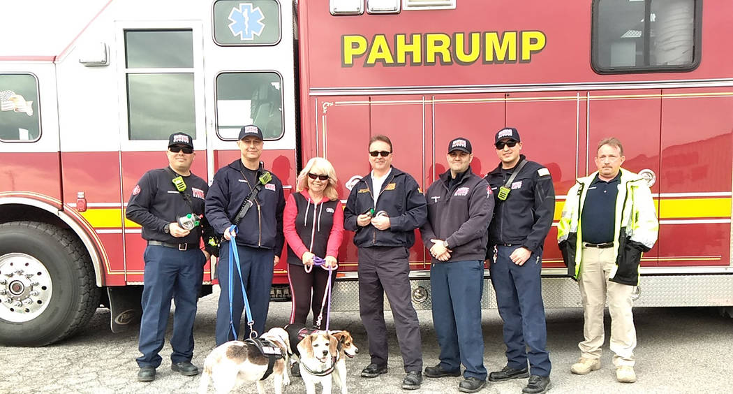 Selwyn Harris/Pahrump Valley Times Giselle Galassi holding her three Beagles stands alongside Pahrump Fire Chief Scott Lewis at her immediate left, following a donation of pet oxygen masks late la ...