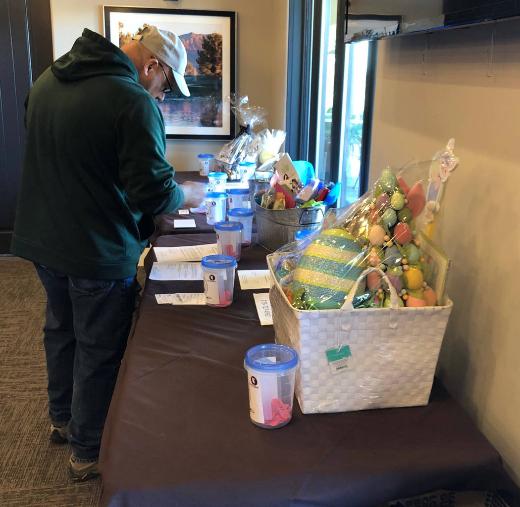 Tom Rysinski/Pahrump Valley Times Raffle prizes are inspected Saturday at Mountain Falls Golf Club after the golf was over at the No To Abuse Golf Tournament in Pahrump.