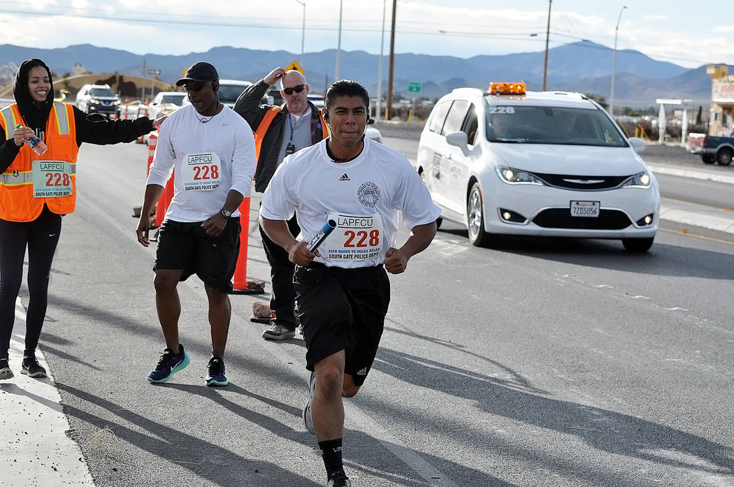 Horace Langford Jr./Pahrump Valley Times The South Gate, California, Police Department team transfers the baton at a checkpoint in Pahrump during last year's Baker to Vegas Challenge Cup Relay.