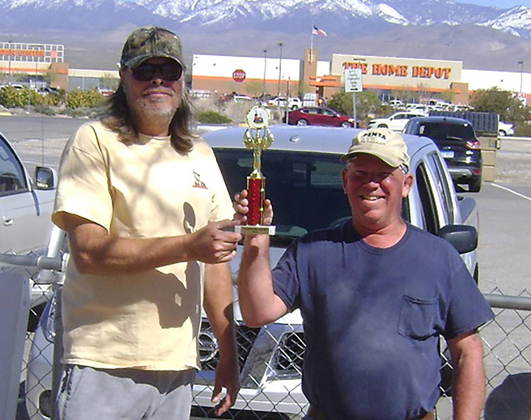 Mike Norton/Special to the Pahrump Valley Times Latham Dilger, left, presents Dave Barefield with the trophy for winning a chili cook-off held during the horseshoes and cornhole tournaments Saturd ...