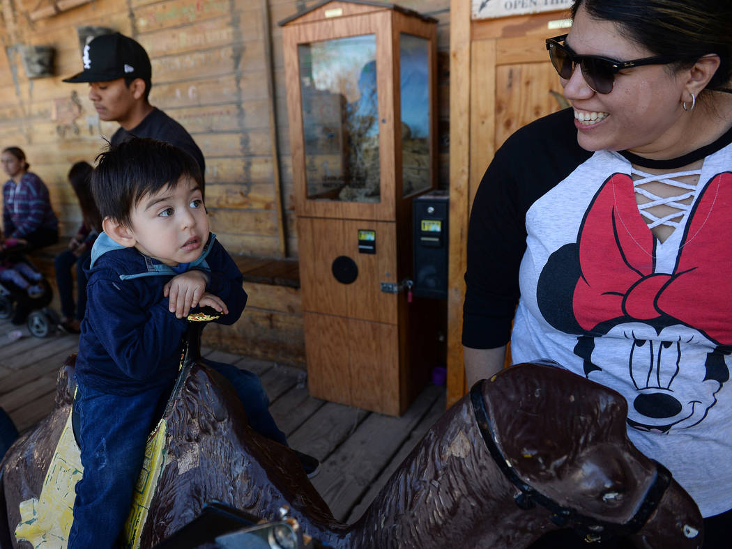 Jonsito Lakins, 2, from Las Vegas sits on a toy camel as he looks at his mother, Karen Lakins, during the last day of operations at Bonnie Springs Ranch in Las Vegas, Sunday, March 17, 2019. (Caro ...