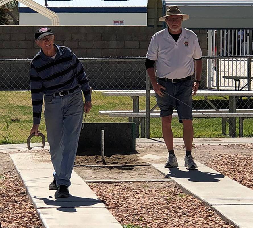 Tom Rysinski/Pahrump Valley Times Fred Kennedy, left, pitches as Don Brown waits his turn during a B Division game at the Pahrump Spring Open horseshoes tournament Saturday, March 23 at Petrack Park.