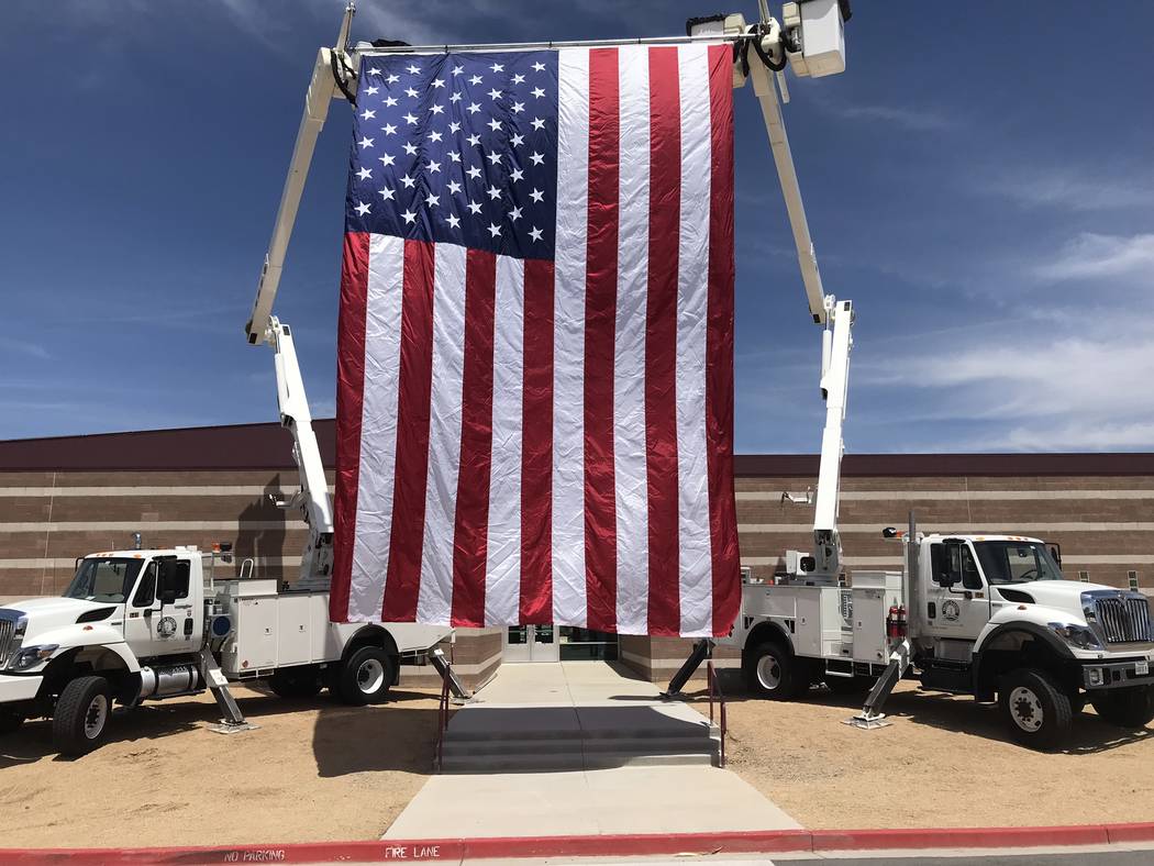 Jeffrey Meehan/Pahrump Valley Times A large American flag blows in the wind between two trucks ...