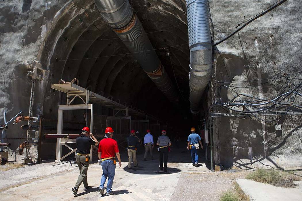 Members of a congressional tour make their way through the north portal of Yucca Mountain near ...