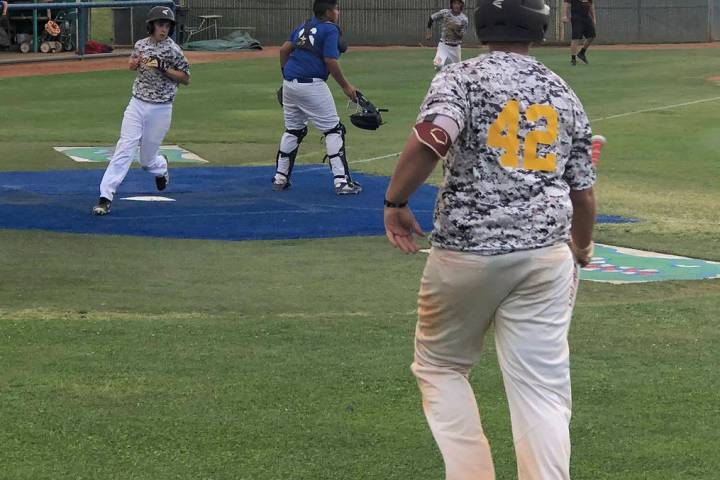 Tom Rysinski/Pahrump Valley Times Pahrump's James Metscher scores a run as Fidel Betancourt rac ...